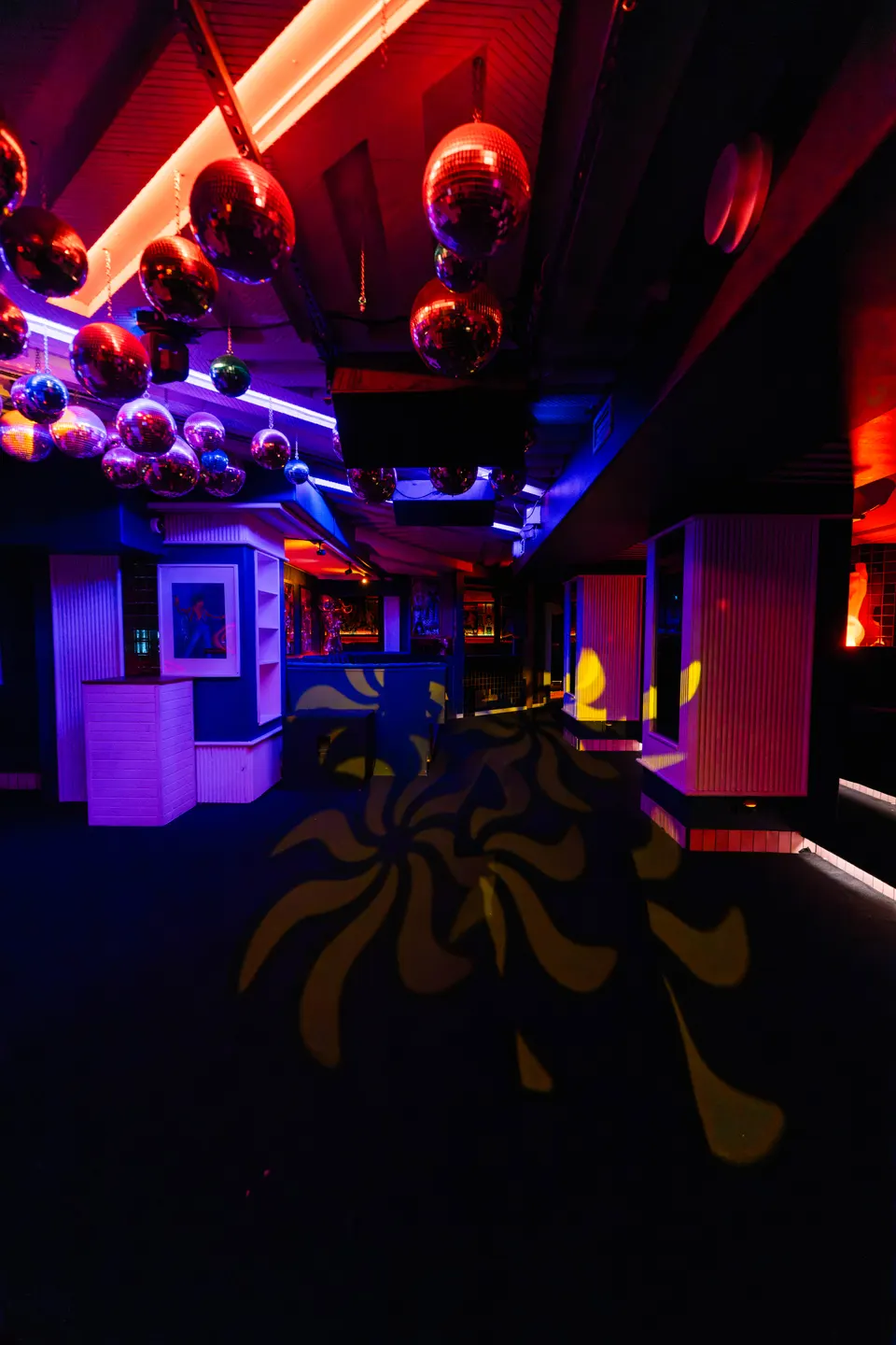 Mirror balls glow violet and magenta above the Pelicano club dancefloor