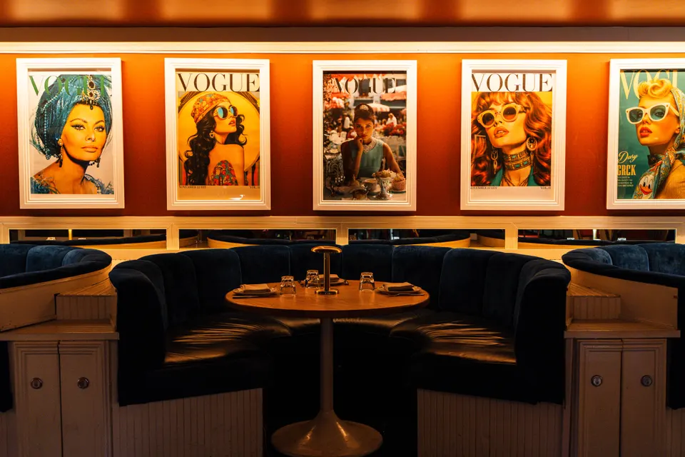 Banquettes beneath a gallery wall of colourful prints